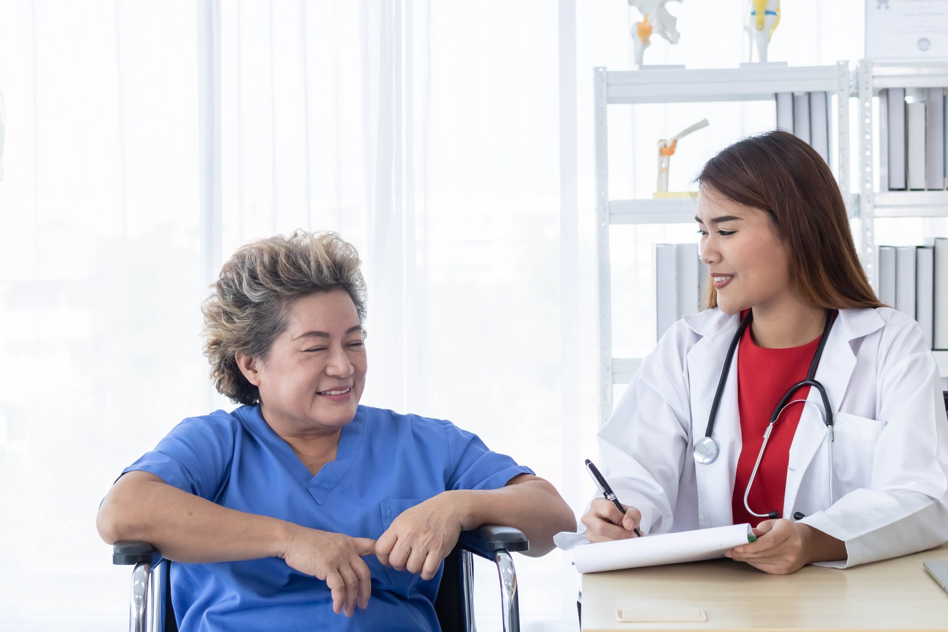 Young attractive Asian doctor is discussing to the patient about her symptoms, healthcare and hospital concept.